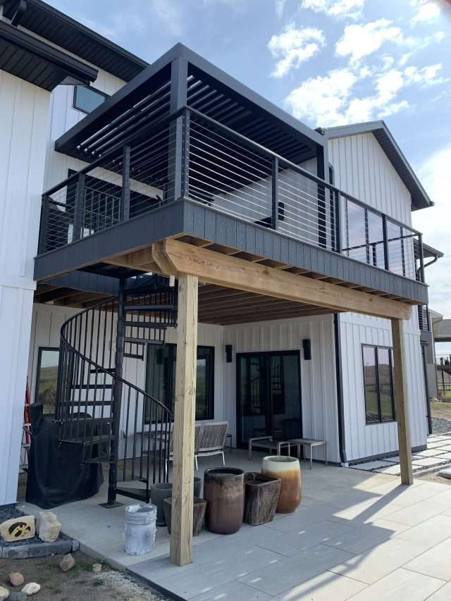 A large deck with stairs leading to the upper floor.