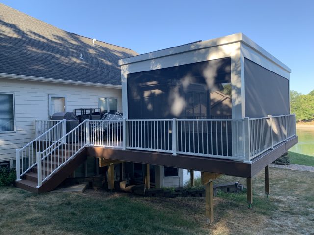 A deck with stairs and a screen in the back.