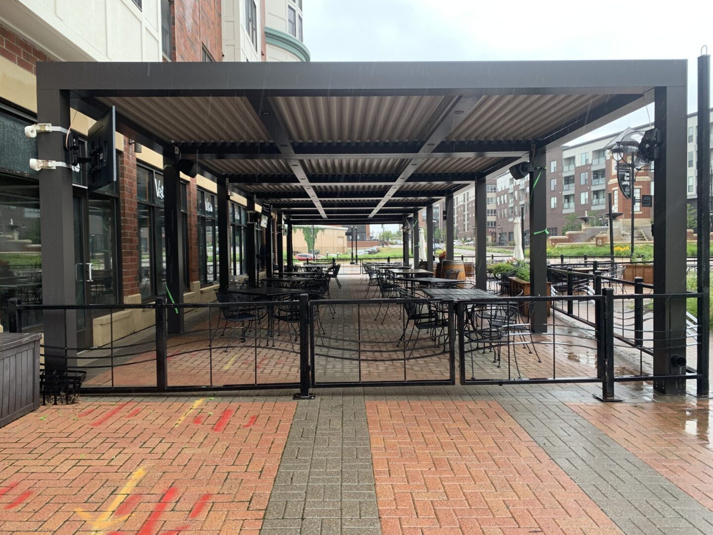 A patio with tables and chairs under an awning.