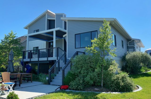 A house with stairs and a lawn in front of it.