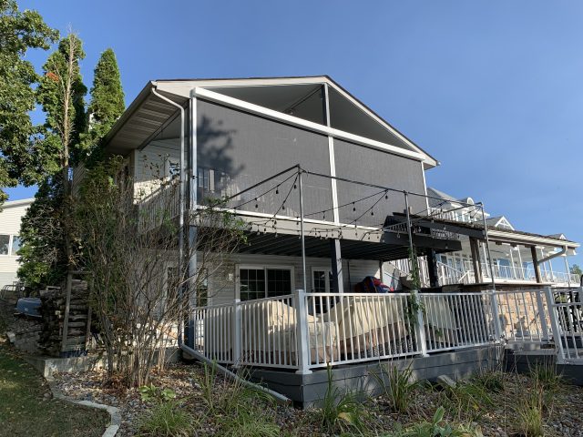 A house with a porch and a deck in the back yard.