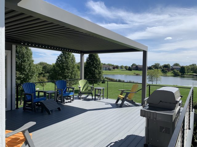 A patio with chairs and tables on the deck.