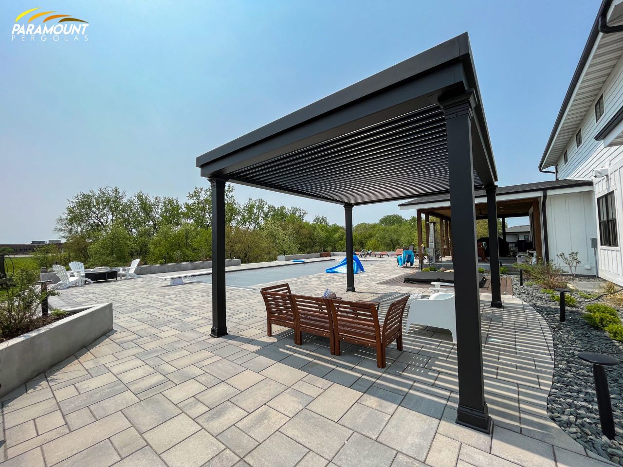 A patio with a pergola and a pool.