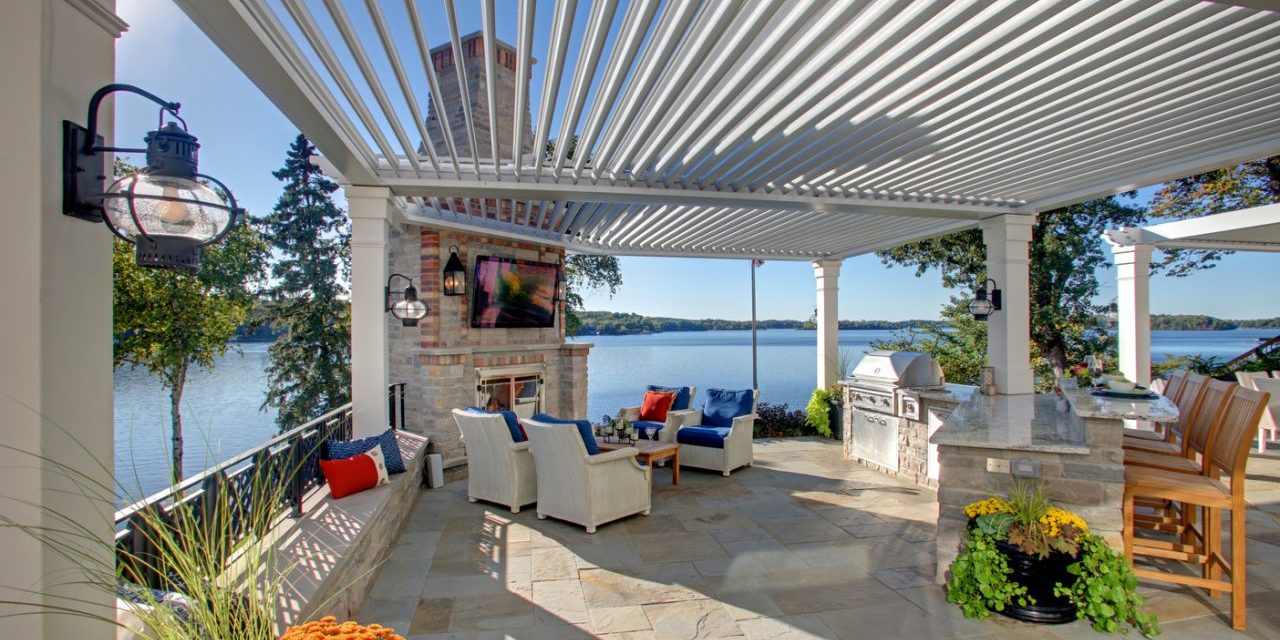 A patio with an outdoor fireplace and a television.